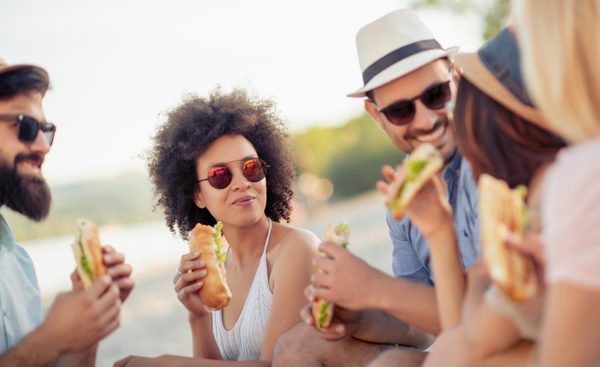 people with sunglasses on eating sandwhiches