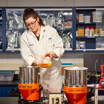 scientist pouring solution in pot