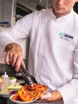 chef with tongs and grilled orange slices