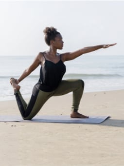 woman doing yoga on beach