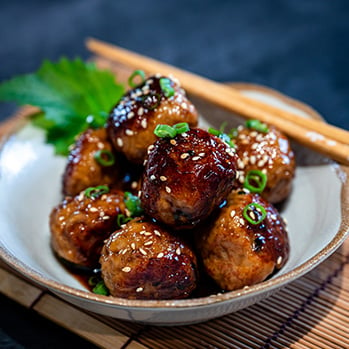 C37 Savory glazed meatball dish with scallions and seasame seeds