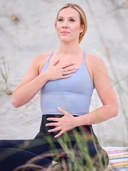 A woman in violet gym clothes exercise on a training mat