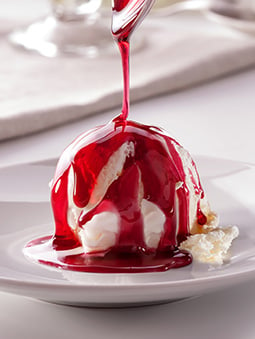 Vanilla ice cream dish with strawberry syrup