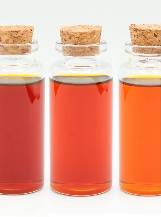 A photo of 3 bottles with Soy Fluid Lecithin. The color of the fluid in the bottles are from dark amber to light amber.