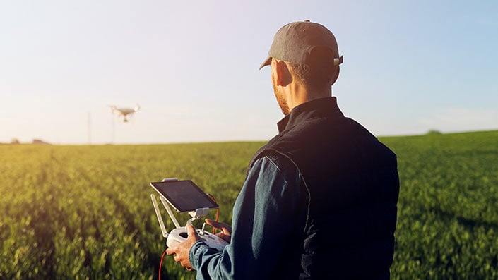 A farmer in a field using technology.